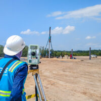 Engineer with complete safety uniform measuring the level of the first stake.