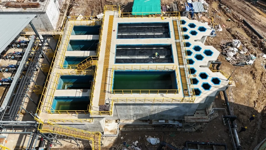 Aerial view of the PT GLS desalination plant at the PT MMP nickel smelter site, showing the large ultrafiltration (UF) pre-treatment basins and industrial piping systems during the final stages of construction.
