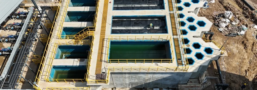 Aerial view of the PT GLS desalination plant at the PT MMP nickel smelter site, showing the large ultrafiltration (UF) pre-treatment basins and industrial piping systems during the final stages of construction.