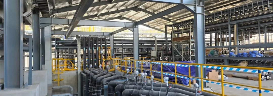 Interior of a large industrial water treatment facility in Indonesia, showcasing extensive piping and filtration systems with the GLS logo visible.