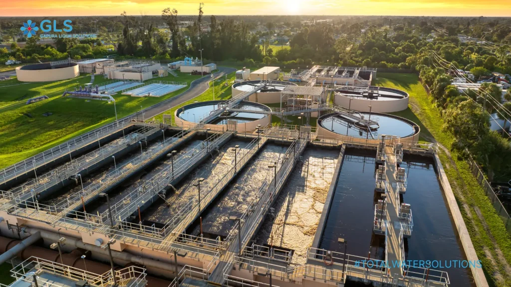 Sludge volume reduction system at industrial wastewater treatment plant using clarifiers and aeration tanks under sunset view.